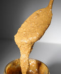 Cremiges Lemke Mandelmus Maple wird aus dem Glas gezogen und zeigt die streichfähige Konsistenz